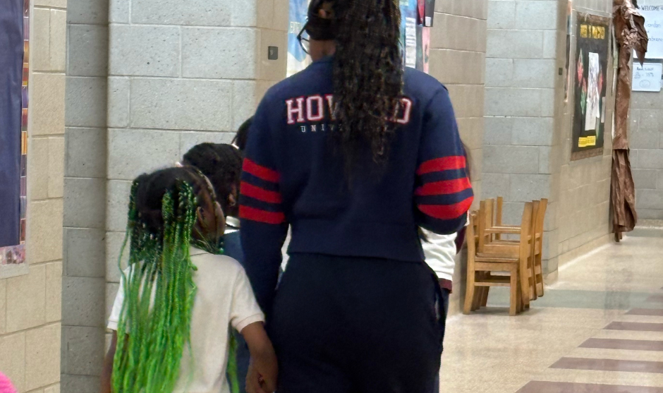 HUASB student walking with a younger student.