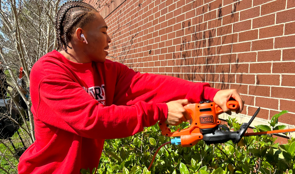HUASB student trimming hedges. 